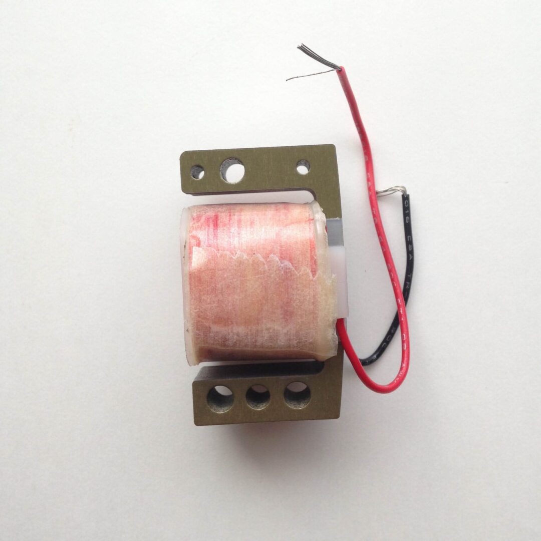 A small transformer with wires attached to it.