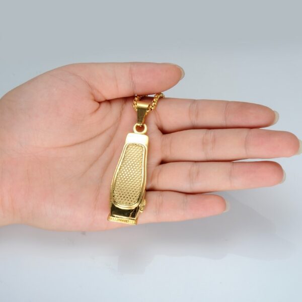 A hand holding a gold key chain in the palm of its hand.