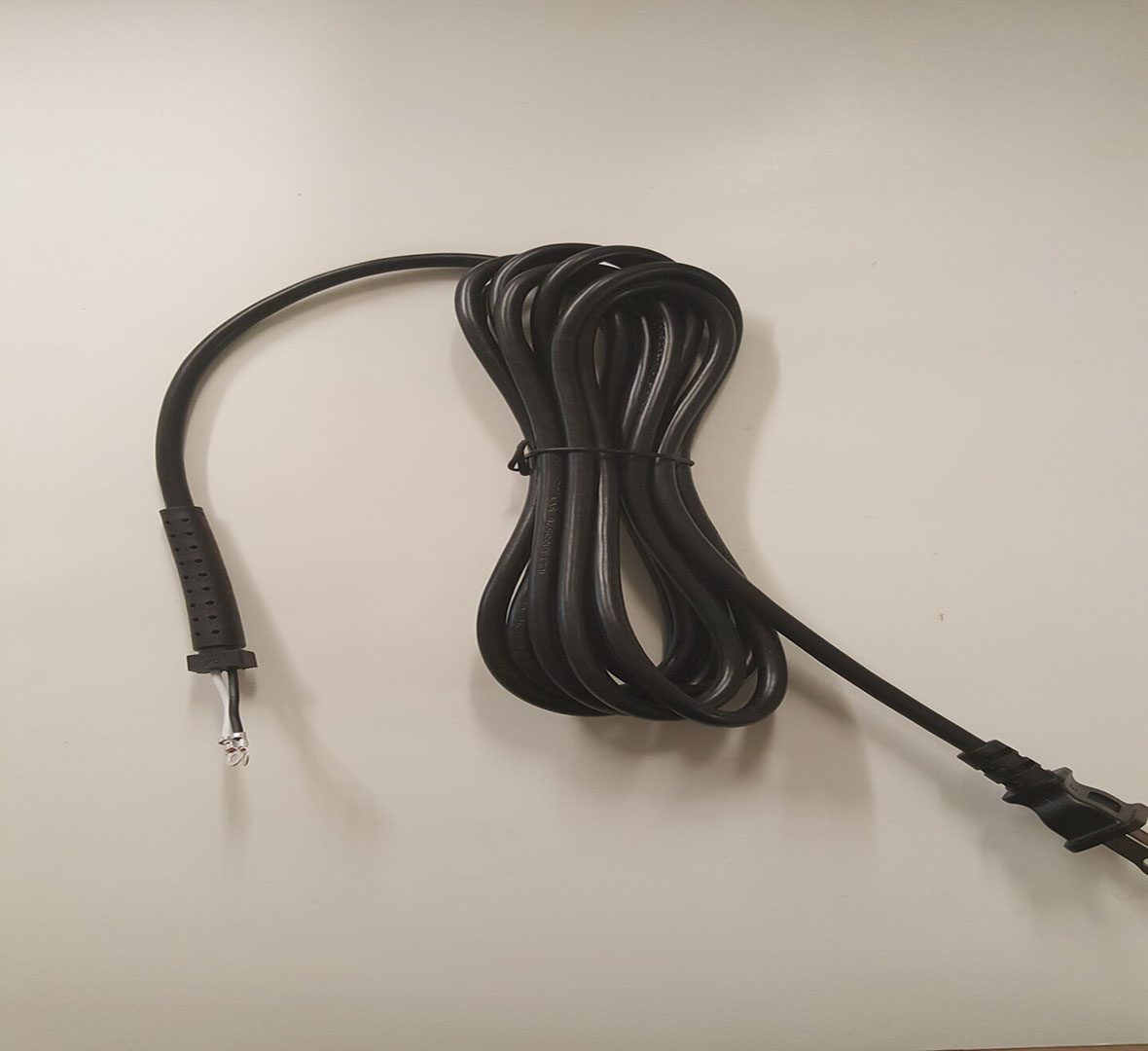 A black cord with an ear bud hanging on it.