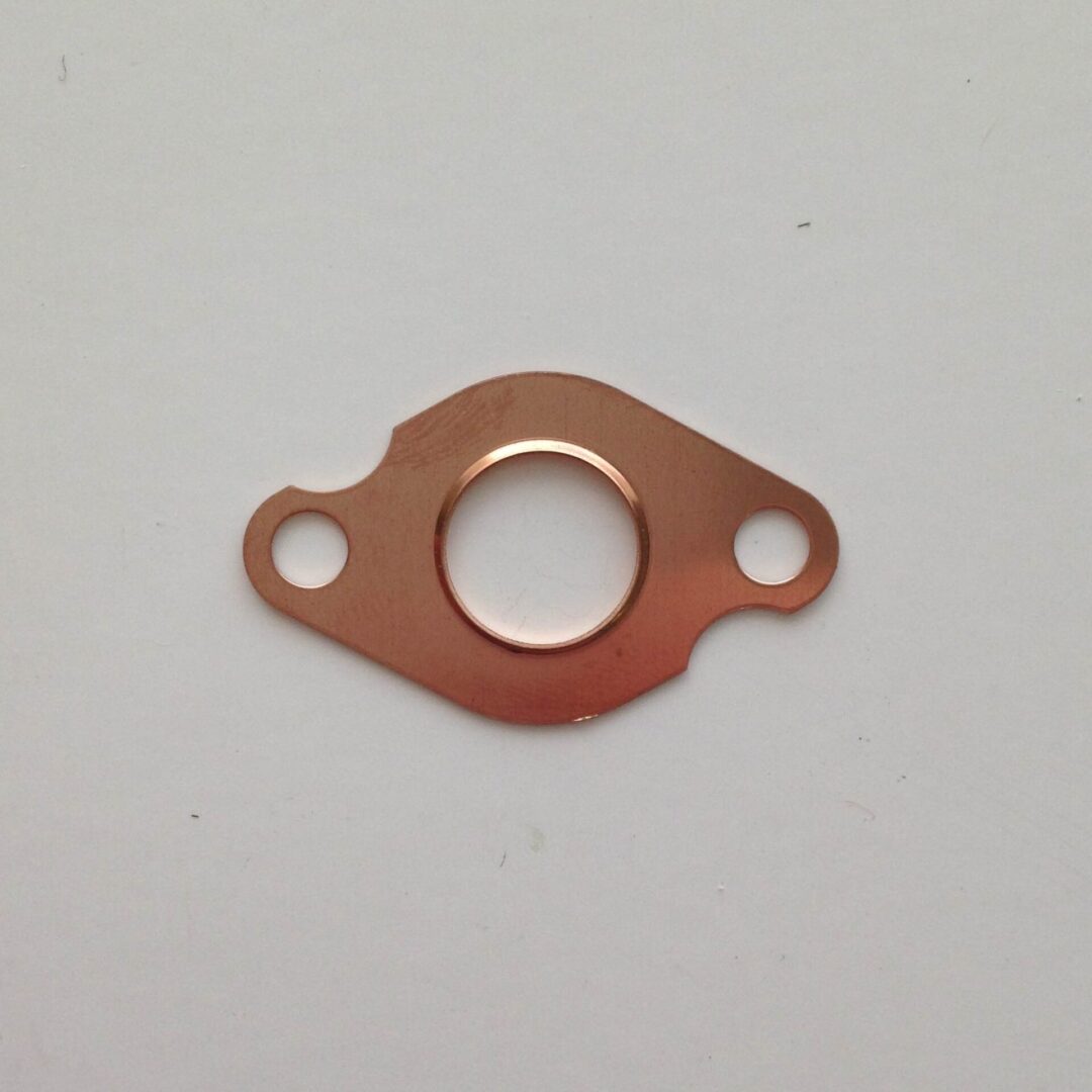 A copper gasket is attached to the side of a car.