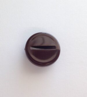 A brown knob on the wall with a hole in it.