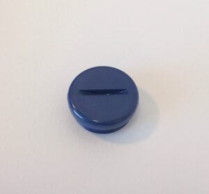 A blue button sitting on top of a table.