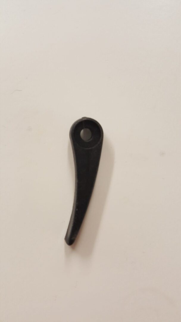 A black plastic handle on top of a white table.
