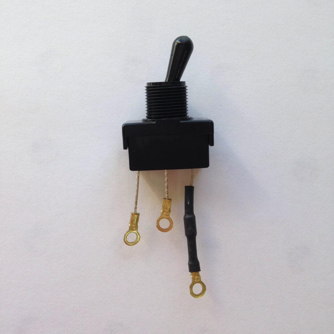 A black switch with three wires attached to it.