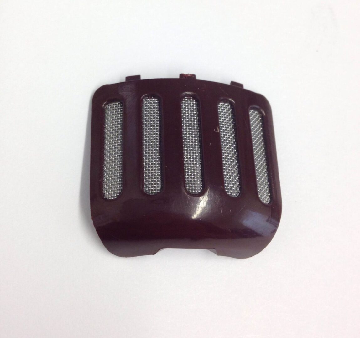 A brown plastic cover with a metal grill.