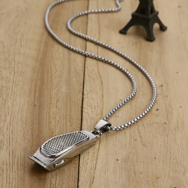 A silver necklace with a metal hair clipper on it.