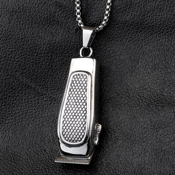 A silver necklace with a metal hair clippers on it.