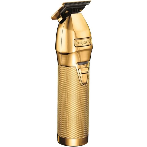 A gold colored hair trimmer sitting on top of a table.