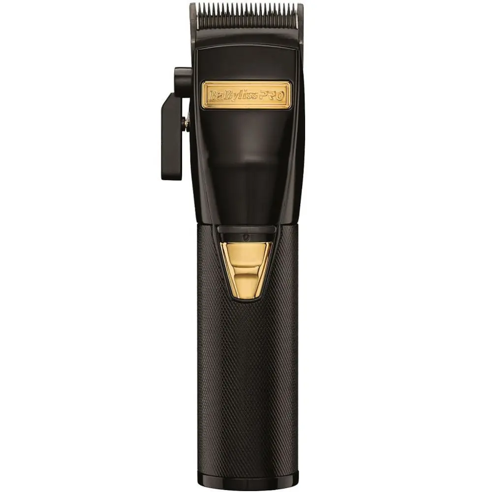 A black and gold hair clipper sitting on top of a table.