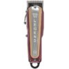 A red and silver hair clipper sitting on top of a table.