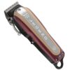 A red and black hair clipper is on the floor.